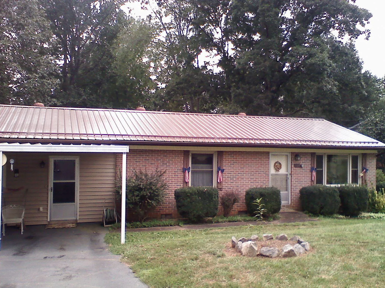 Bronze metal roof and carport on a brick ranch home — Roof Repair work by our crew in Stella